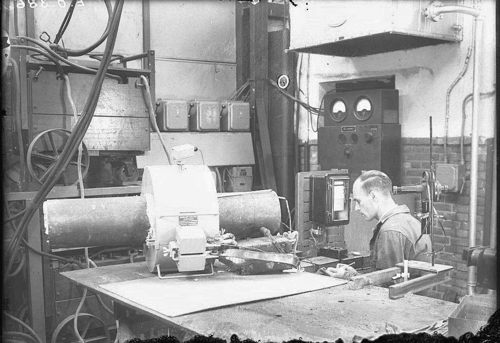 Medewerker van het laboratorium van Smit Ovens test een machine (1940)